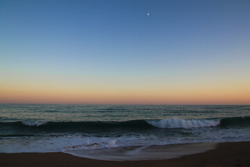 Fototapeta na wymiar Cielo de atardecer en el mar con luna menguante
