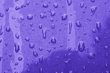 Water droplets bead on a periwinkle colored surface
