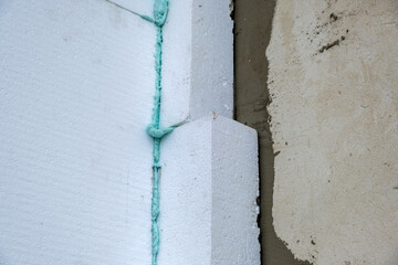 Installation of styrofoam insulation sheets on house facade wall for thermal protection
