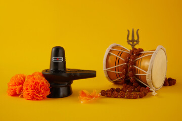 Happy Maha Shivaratri greeting card - Shiva Linga decorated with flowers, trishula, and damru....