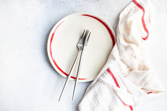 Overhead View Of A Minimalistic Place Setting And Napkin With A Red Stripe