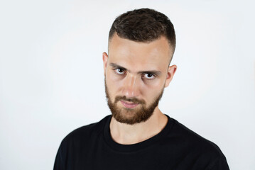 Obraz premium Portrait of a young man with a beard and a sad look, the guy has problems with a girl and he has a headache from stress. The concept of a headache in a young man and loneliness