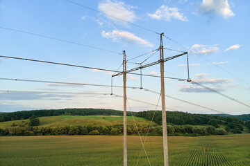Tower with electric power lines for transfering high voltage electricity located in agricultural cornfield. Delivery of electrical energy concept