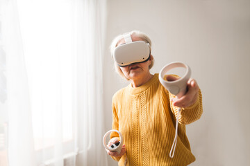  virtual reality. VR, future, gadgets. senior woman playing game in virtual reality glasses and...