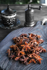 Fresh organic fruits and spice seeds from star anise with a spice grinder. Organic dry star anise. aniseed stars on a dark rustic background