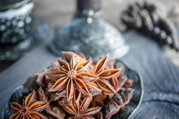 Fresh organic fruits and spice seeds from star anise . Still life in Arabic style. Organic dry star anise. aniseed stars on a dark rustic background