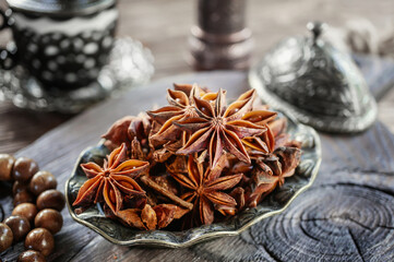 Fresh organic fruits and spice seeds from star anise . Still life in Arabic style. Organic dry star anise. aniseed stars on a dark rustic background