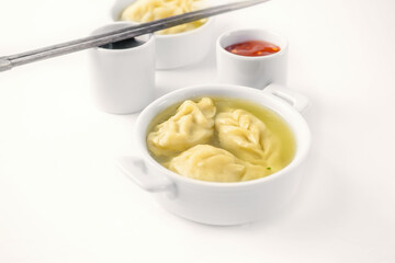 Steamed dumplings and soy sauce. asian dumplings Gyoza potstickers in white ceramic plate served with chopsticks over linen table cloth. Asian dinner.