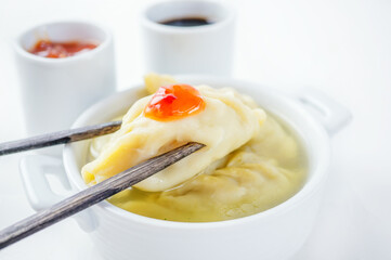 Steamed dumplings and soy sauce. asian dumplings Gyoza potstickers in white ceramic plate served with chopsticks over linen table cloth.