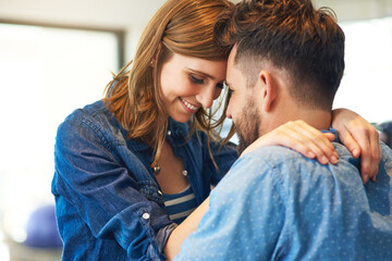 He won her heart with his love filled hugs. Shot of an affectionate young couple at home.