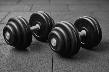 Dumbbells on a floor. Bodybuilding equipment. Fitness or bodybuilding concept background. black and white photography..