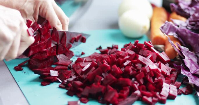 Cooking at home, beet root chopping using kitchen knife, close-up
