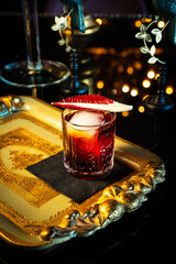alcoholic red cocktail with ice and radicchio leaf on tray