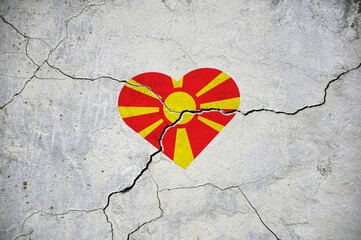 The symbol of the national flag of North Macedonia in the form of a heart on a cracked concrete...