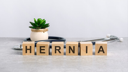 hernia word written on wooden blocks and stethoscope on light gray background