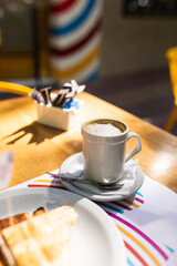 coffee next to toasted ham and cheese sandwiches