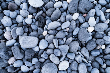 Gray pebbles as a background. Round stones on the beach. Photography for design. Textures in nature.