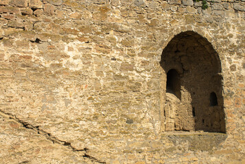 Holes for medieval guns in a defensive fortress. Space for protection in stone walls. The point of warfare in the citadels. Details of architecture.