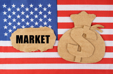 On the US flag there is a cardboard figure of a money bag and a cardboard with the inscription -...
