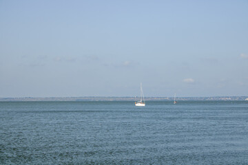 White yacht sail in sea on the background blue sky. Taking an adventurous boat cruise. Sailing boat on open water.