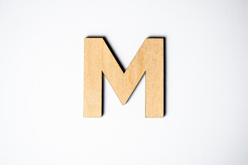 Wooden letter M on white background