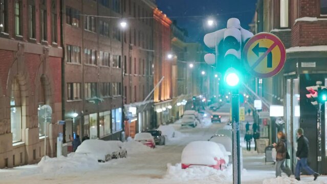 The traffic light in the foreground, the blurred view of the street in Central Helsinki during the strong snowstorm in the background. Finland