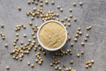 White ground pepper and whole peppercorn spice in bowl.