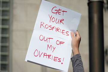 A hand holding a sign supporting women's reproductive freedom during a planned parenthood rally for abortion justice.