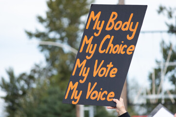 A hand holding a sign supporting pro-choice abortion laws during a planned parenthood rally for...