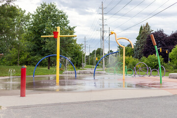 Splash pad playground in public park in summer without people. Fountains with splashing water