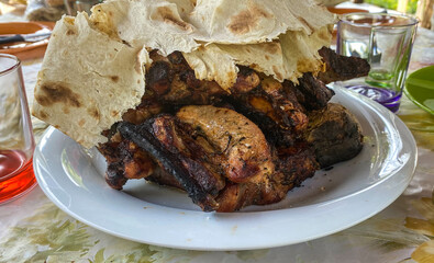 Pieces of pork shish kebab covered with pita bread on a plate. close-up