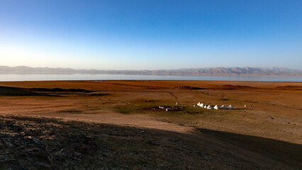 Obraz premium Camp de yourtes au soleil couchant sur les rives du lac Son Kul au Kirghizistan