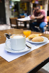 coffee with milk with orange juice and croissants