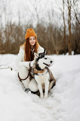 Fototapeta na wymiar cheerful woman in the snow playing with a dog outdoors friendship winter holidays
