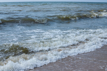 Sea wave with spray and foam near the shore