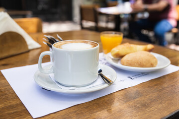 coffee with milk with orange juice and croissants