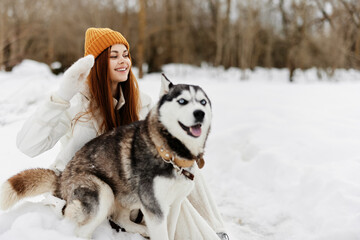 young woman outdoors in a field in winter walking with a dog winter holidays