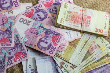 Paper money different denominations, Ukrainian hryvnia in denominations 50,100, 200 hryvnias, new money, background with scattered banknotes