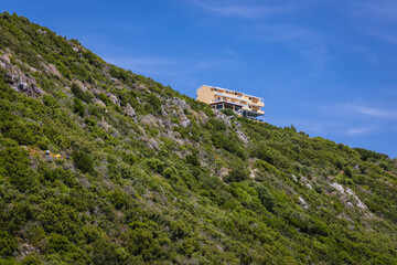 Fototapeta premium Hotel and restaurant over path to Porto Timoni double beach near Agios Georgios village, Corfu Island, Greece