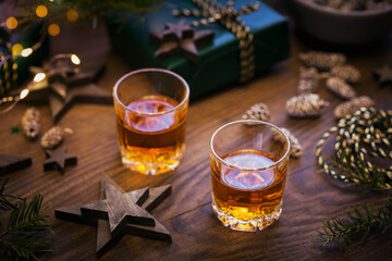 Two shot glasses of whiskey or bourbon with Holiday decoration