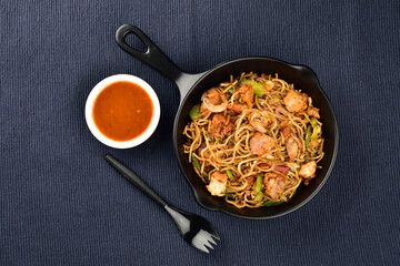 chicken noodles served with sauce on blue kitchen cloth