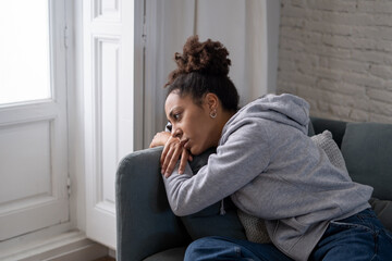 Sad black woman suffering from depression symptoms feeling distressed alone at home - obrazy, fototapety, plakaty