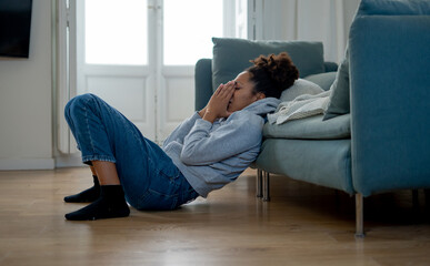 Sad black woman suffering from depression symptoms feeling distressed alone at home