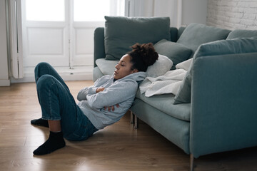 Obraz premium Sad black woman suffering from depression symptoms feeling distressed alone at home