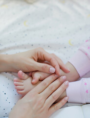 Mother holding baby girl feet