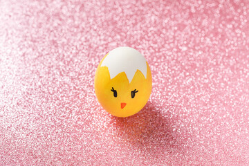 Easter background, Easter painted egg on the pink shiny texture.