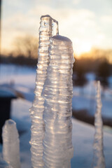 Icicle on the background of the spring sky at sunset.