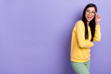 Photo of young cheerful pretty girl interested look empty space oculist isolated over purple color background
