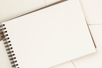 Open blank sheet of sketchbook on spiral, light background, copy space - obrazy, fototapety, plakaty