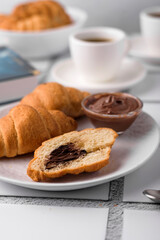 coffee and croissants, chocolate cream, french press on the table, morning breakfast 